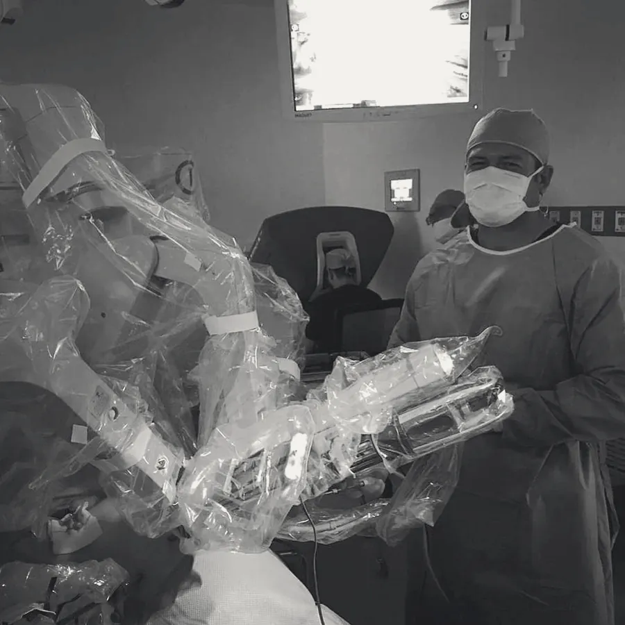 Dr. Jorge Rosales junto a un brazo del sistema quirúrgico robótico